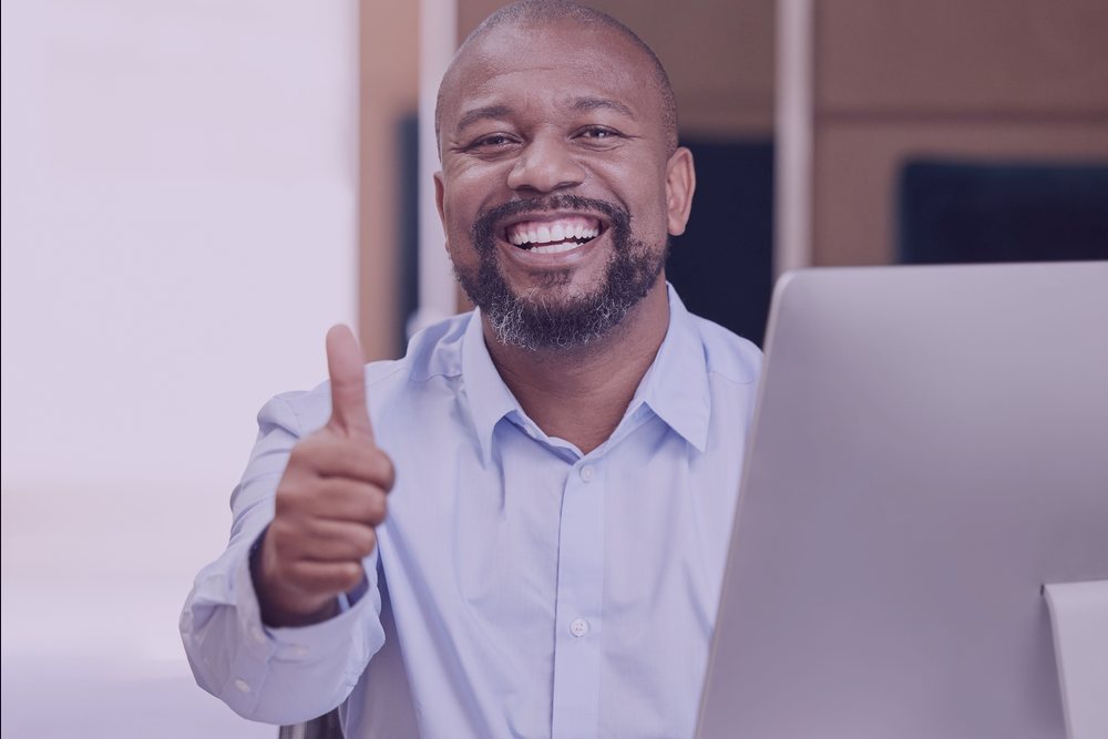 A Padre Pio client giving a thumbs up at his desk